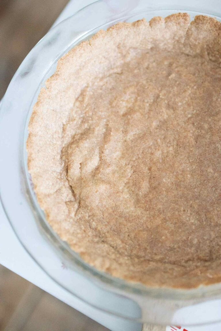 Par bakes fresh milled pie crust sitting on a cutting board, offset in the shot.