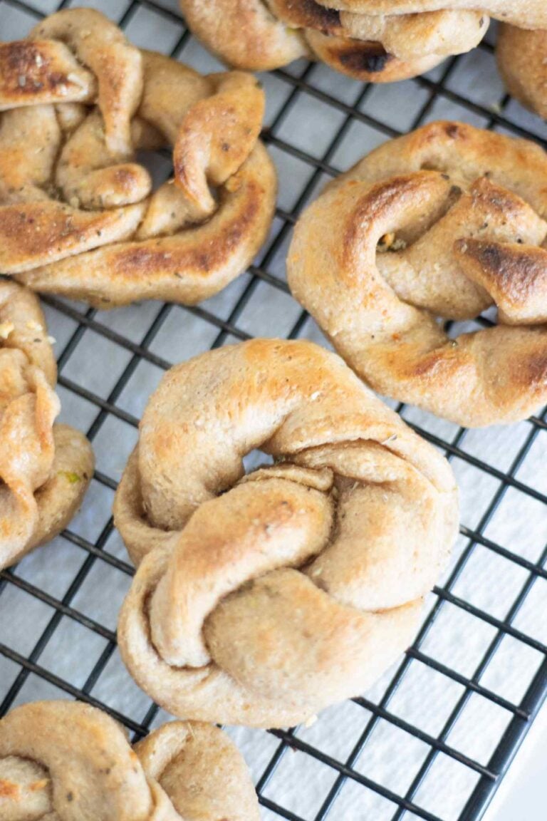 sourdough garlic knots on a wire cooling rack. They are golden brown.