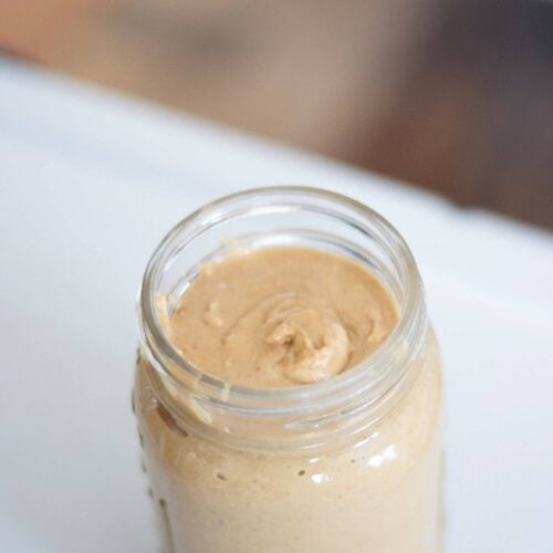 an overhead photo of peanut butter in a glass jar