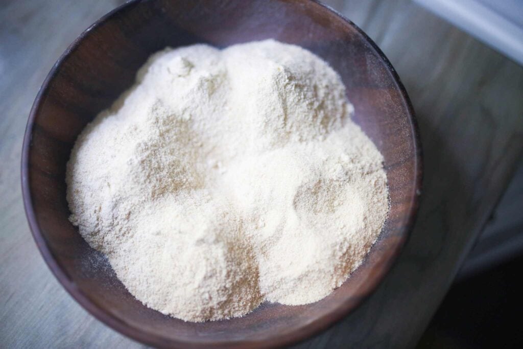 There is a wooden bowl with flour in it. This is Kamut flour.