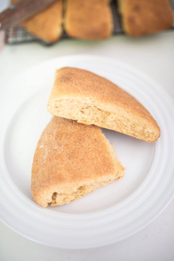 2 pieces of ciabatta bread on a white plate.