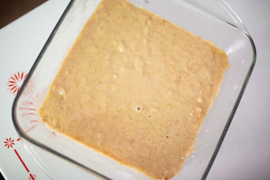 Banana bar batter in a glass square pan.