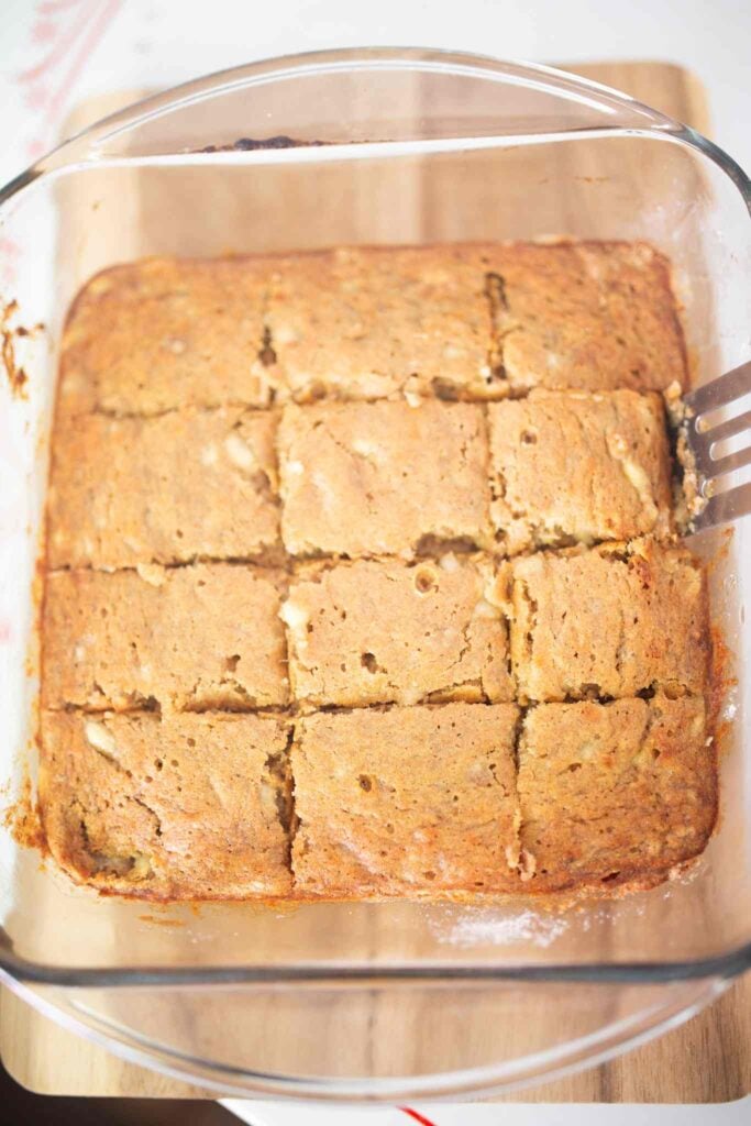 A square glass pan of banana bars sliced into bars.