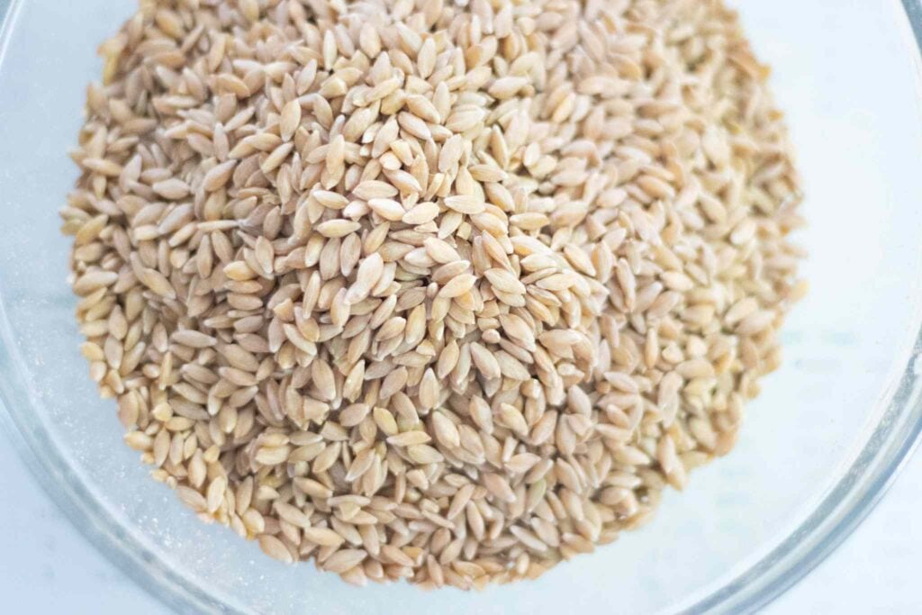There is a glass bowl full of grains.