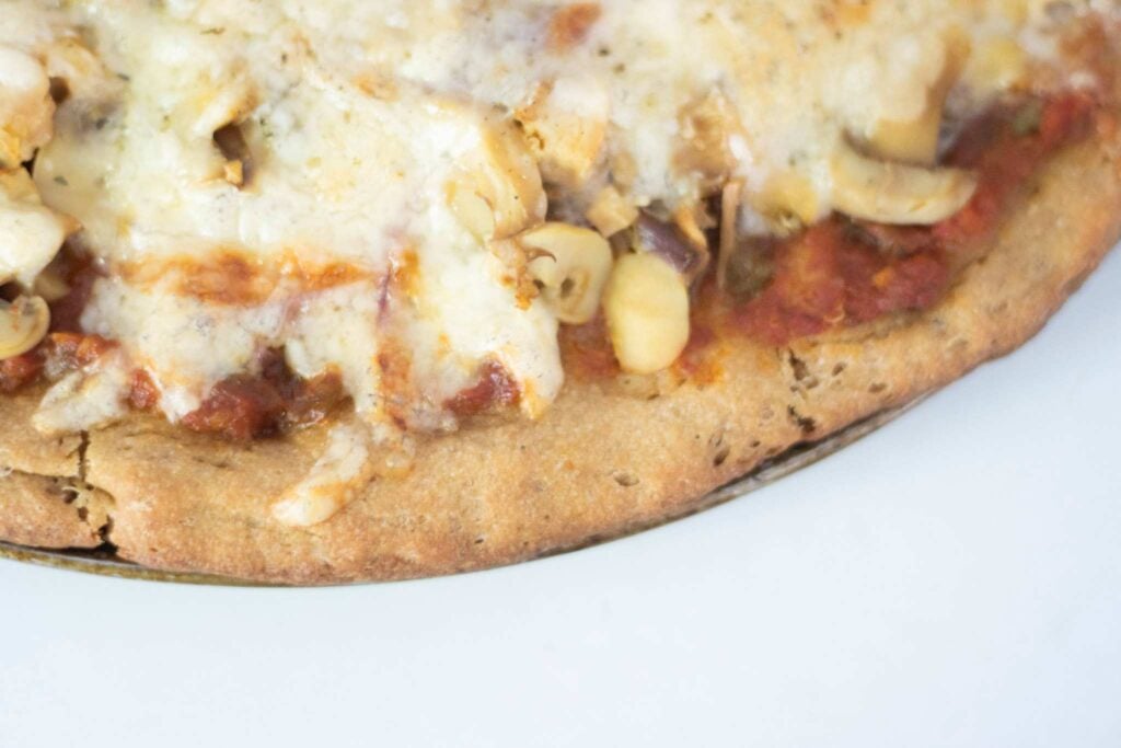 A close up of a pizza showing the golden brown crust on the edge.