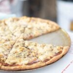 Pizza on a pizza pan with one slice missing.