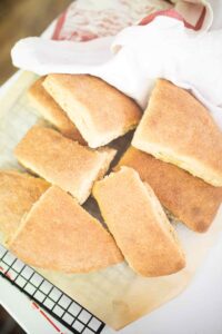 Pieces of ciabatta bread are stacked on top of each other on a piece of parchment paper.