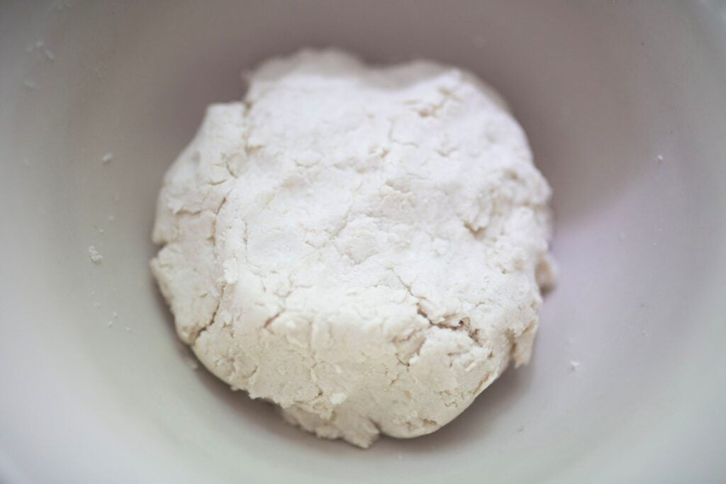 Biscuit dough in a cream colored mixing bowl.