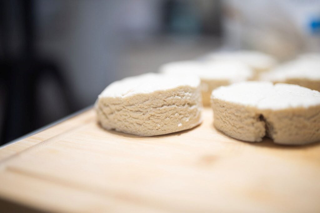 Shaped biscuit dough on a cutting board showing the texture of the dough.