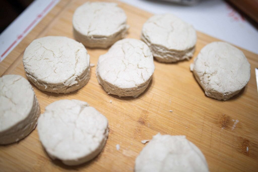 An overhead picture of shaped biscuit dough on a wooden board.