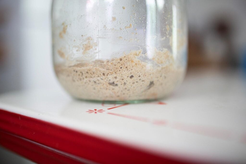A small amount of sourdough starter in a glass jar.