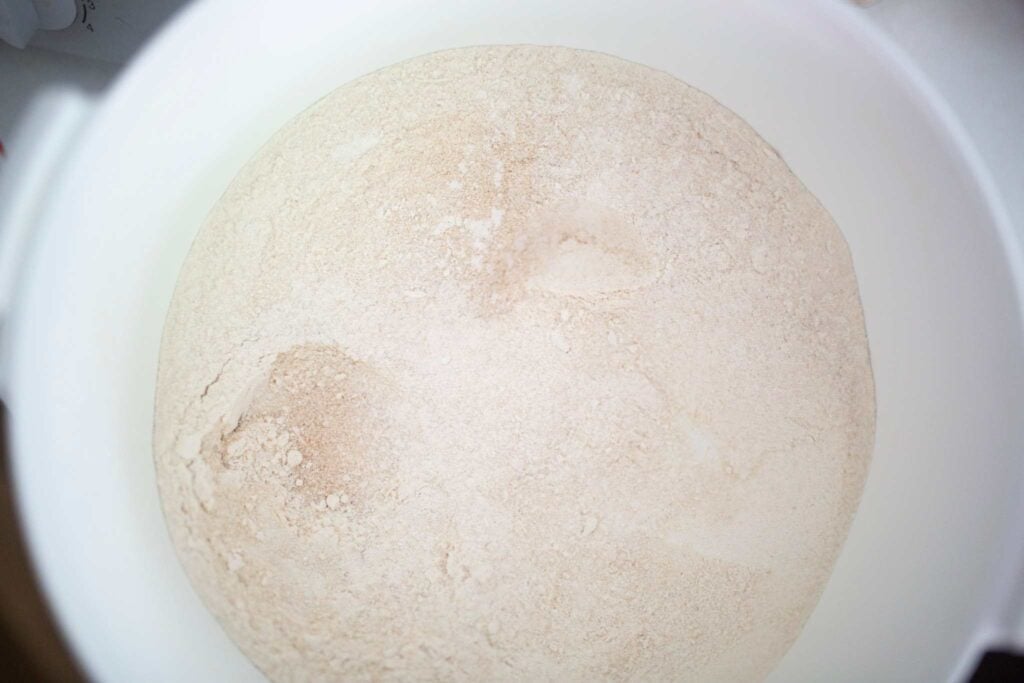 A big white bowl is full of flour.