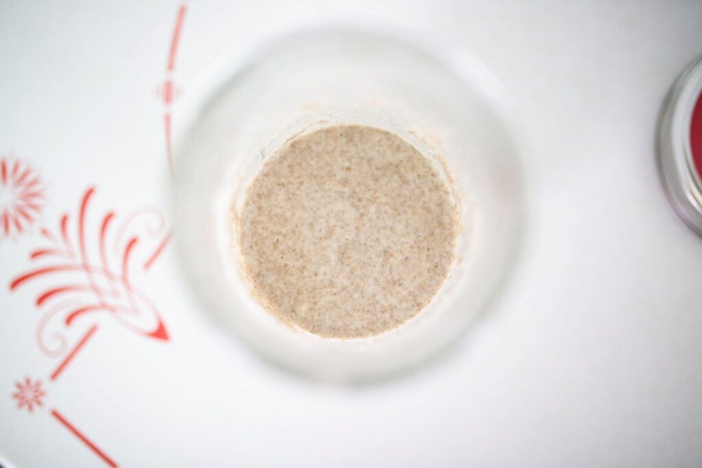 Inactive sourdough starter in a glass jar overhead.