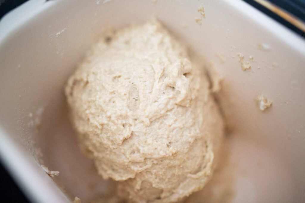 There is a shaggy dough ball in a cream colored pan.