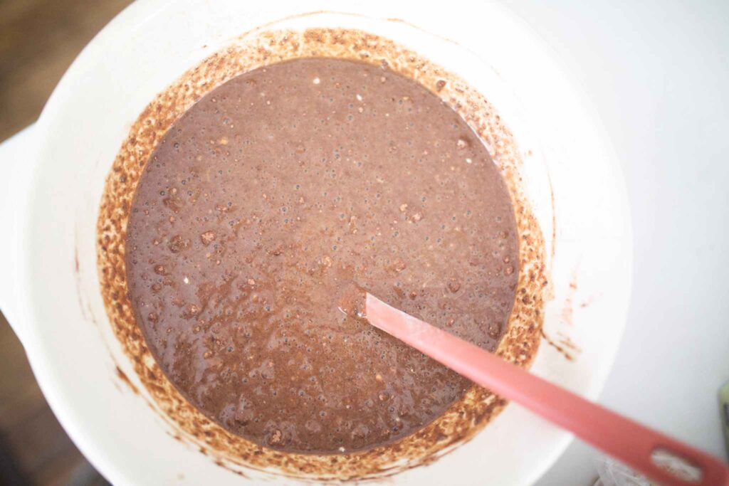 chocolate cake batter in a cream colored bowl.
