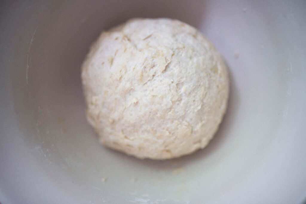 Dough ball in a white mixing bowl.