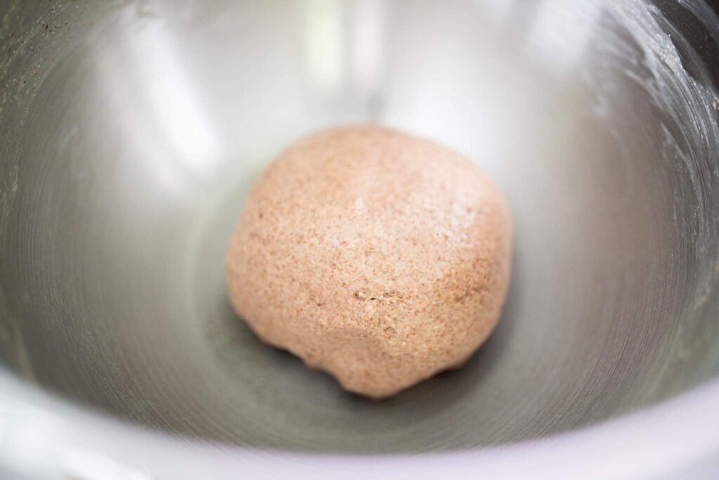 A dough ball in a silver bowl.