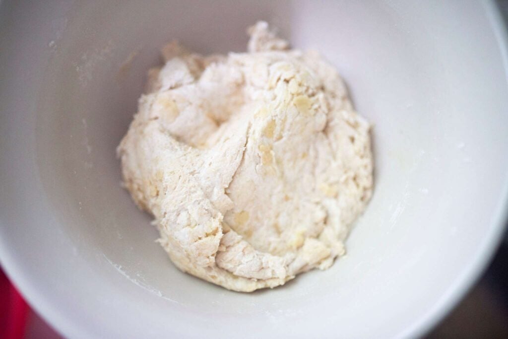 Shaggy dough in a white mixing bowl.