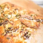 Cheesy topped breadsticks with 2 removed and laying on top.