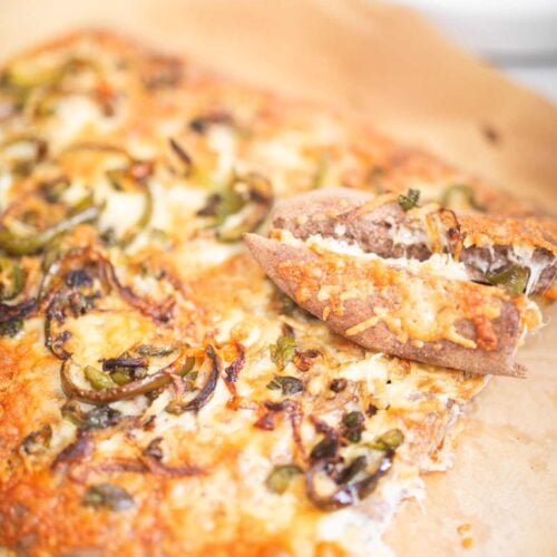 Cheesy topped breadsticks with 2 removed and laying on top.