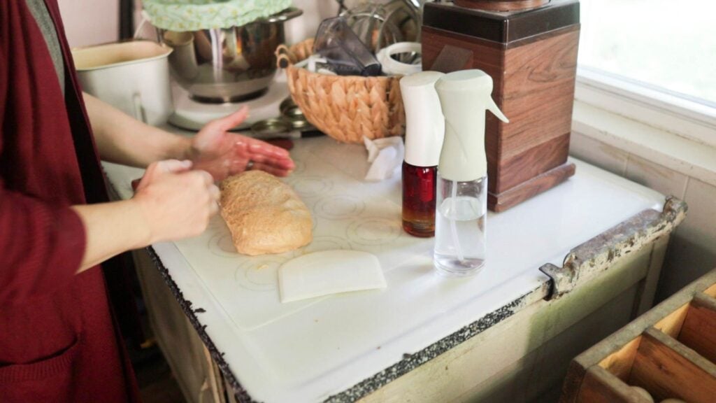 Shaping a sandwich loaf of dough on a counter.