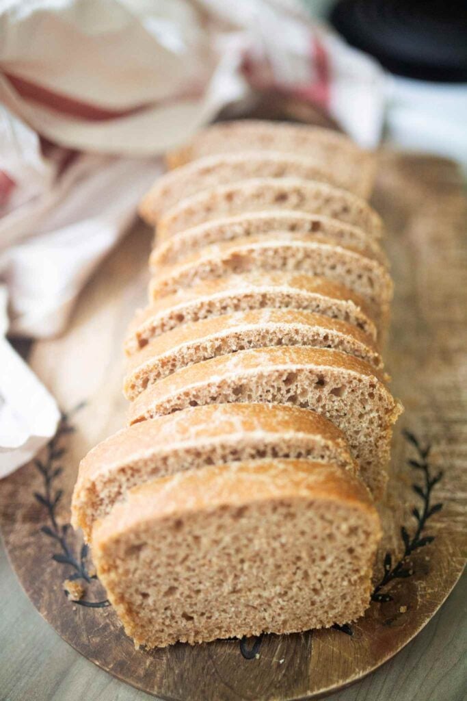 An overhead photo of a sliced loaf of sandwich bread on a cutting board.