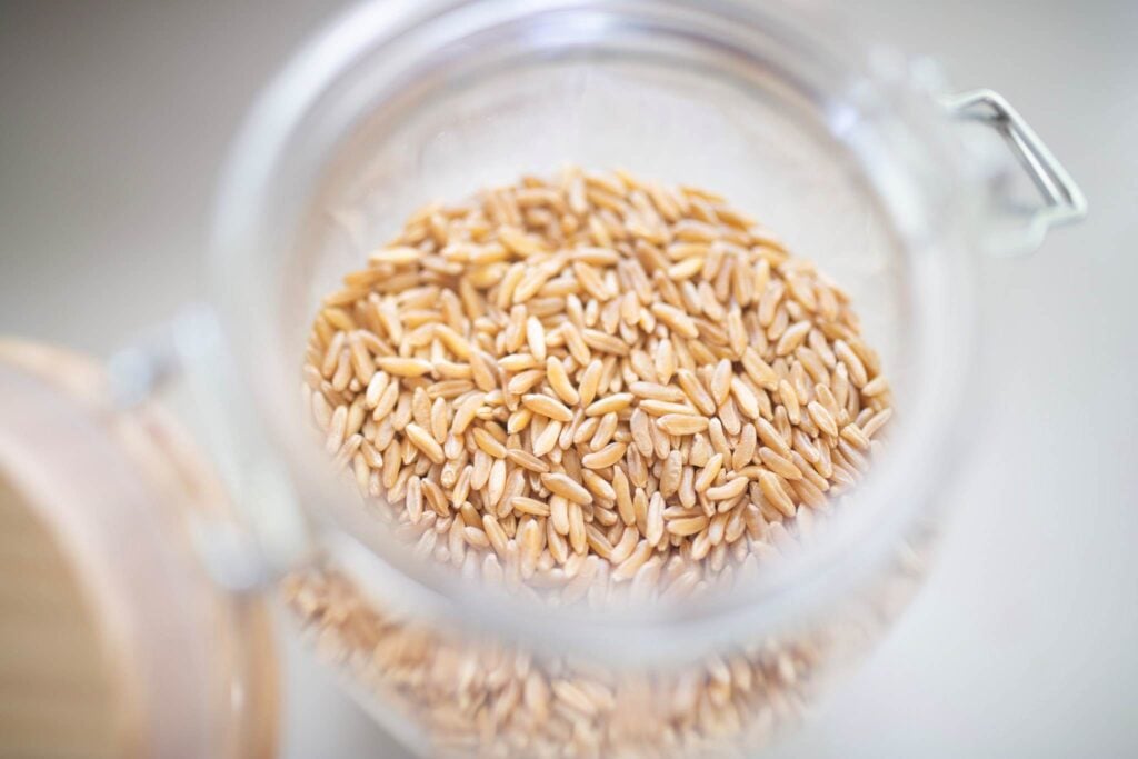 A glass jar full of whole grains.