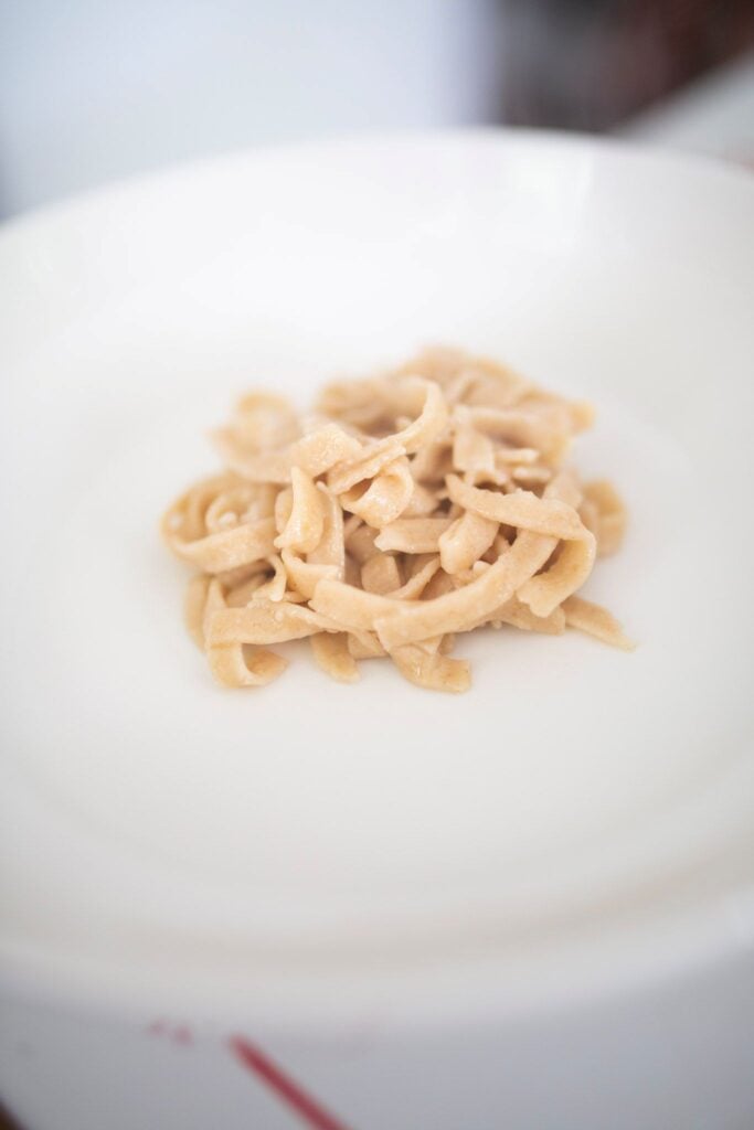 A mound of pasta noodles on a white dinner plate.