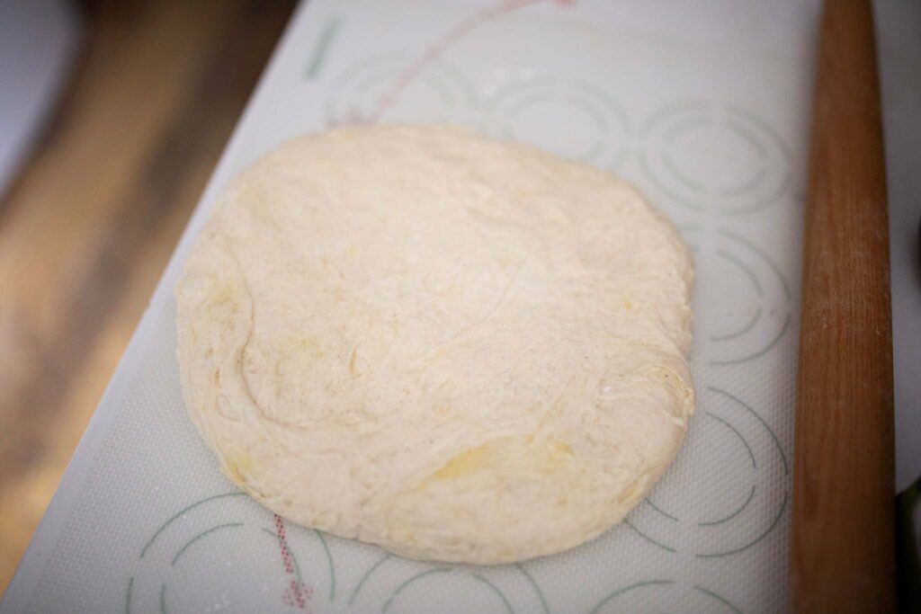 Biscuit dough is rolled out on a counter.