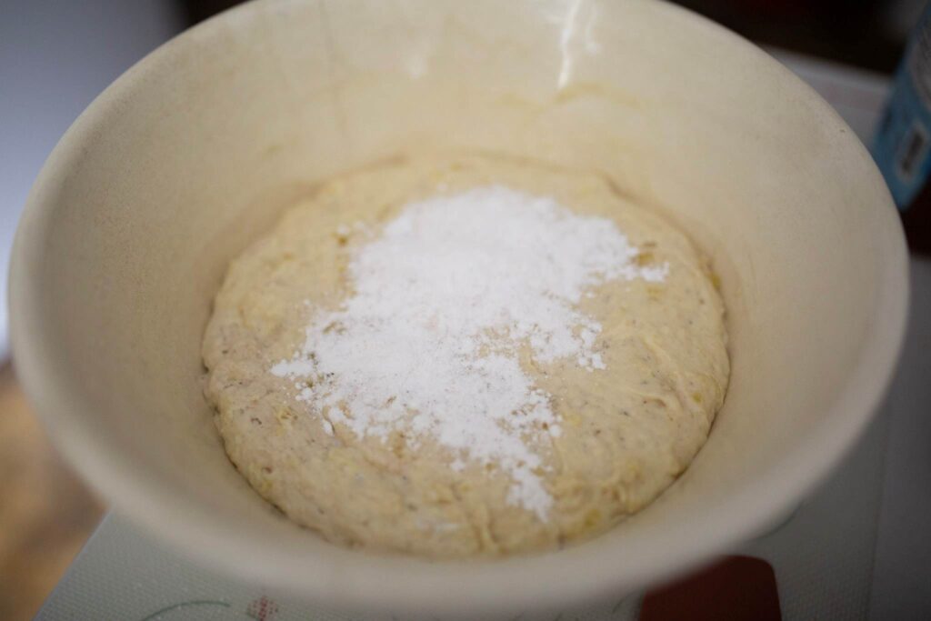 biscuit dough is topped with white powder in a bowl.