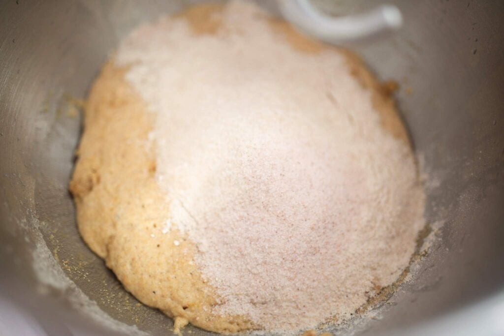 Dough is topped with salt and flour in a bowl.