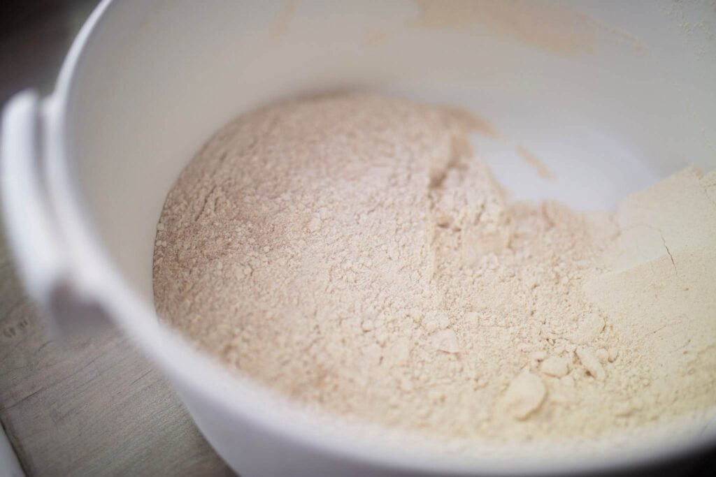 This is a large white bowl full of flour.
